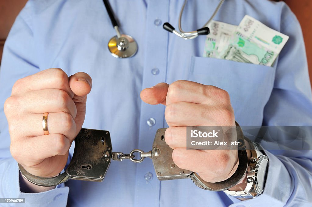 Człowiek z Stetoskop daje jego ręce w kajdanki przed siebie - Zbiór zdjęć royalty-free (Areszt)