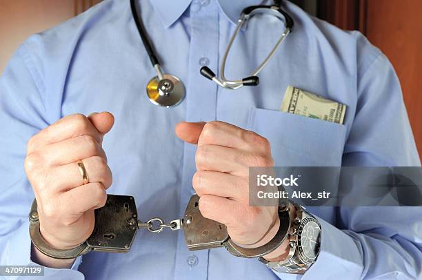 Man With Stethoscope Holds His Hands In Handcuffs Before Itself Stock Photo - Download Image Now