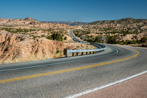 A road winds through New Mexico's high desert on the high road from Santa Fe to Taos