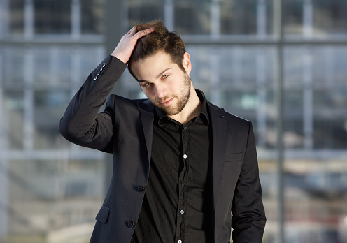 Close up portrait of a handsome male fashion model posing with hand in hair