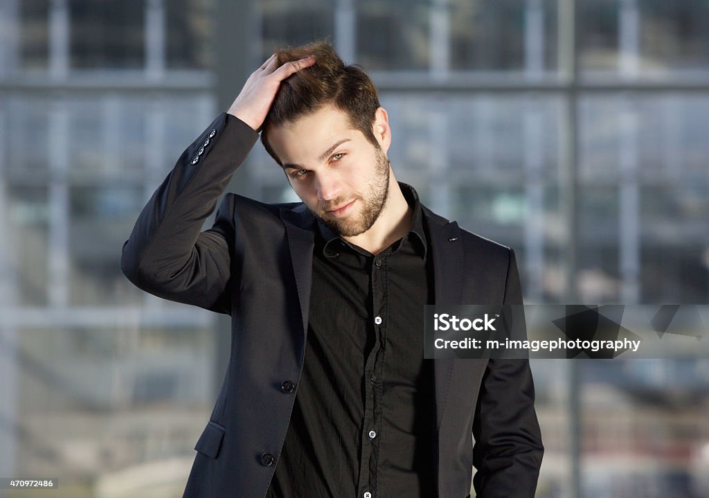 Handsome male fashion model posing with hand in hair Close up portrait of a handsome male fashion model posing with hand in hair Hand In Hair Stock Photo