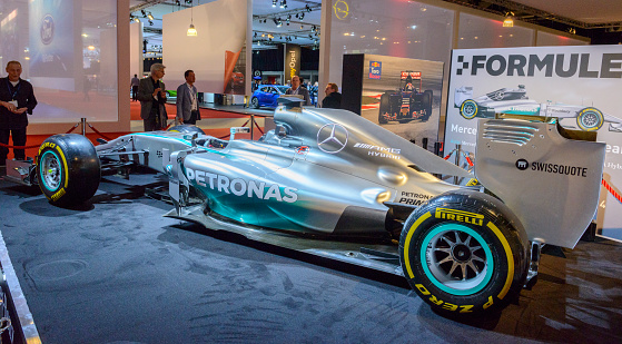 Amsterdam, The Netherlands - April 16, 2015: MERCEDES AMG PETRONAS Mercedes F1 W05 Hybrid F1 race car on display during the 2015 Amsterdam motor show. People in the background are looking at the cars.