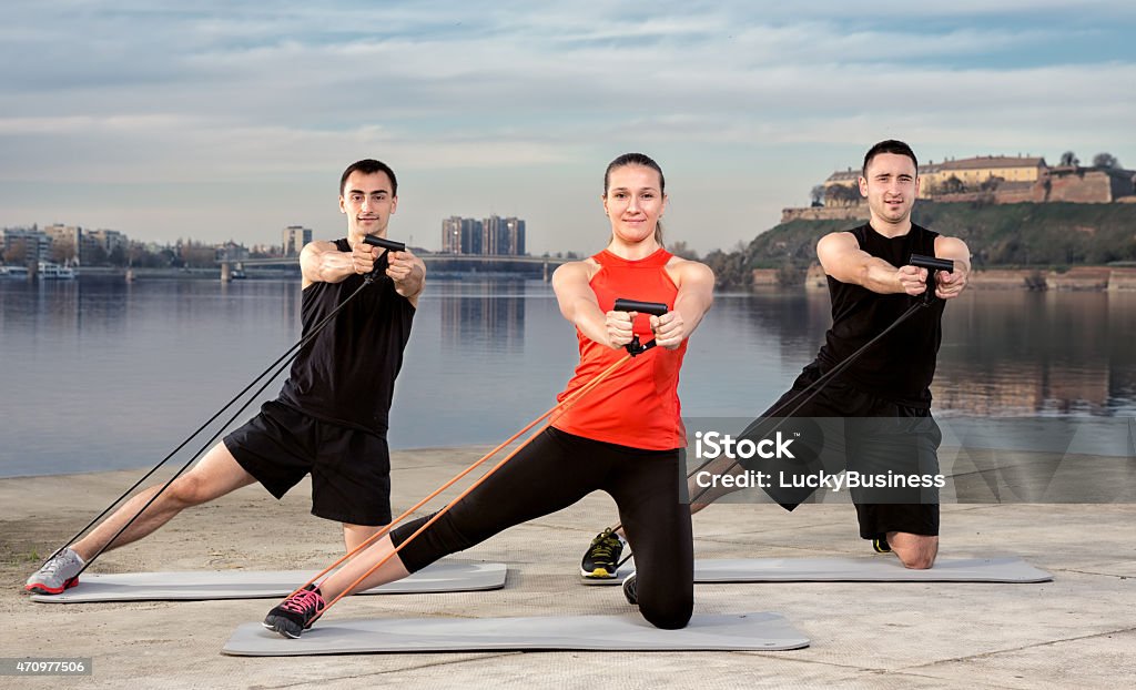 Three young people exercising Three young people exercising, stretching band training 2015 Stock Photo