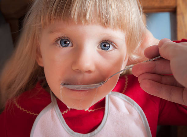 istock Baby girl being fed by hand. 470977907