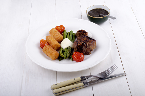grilled lamb chop with green asparagus, cherry tomato, mint sauce and croquettes