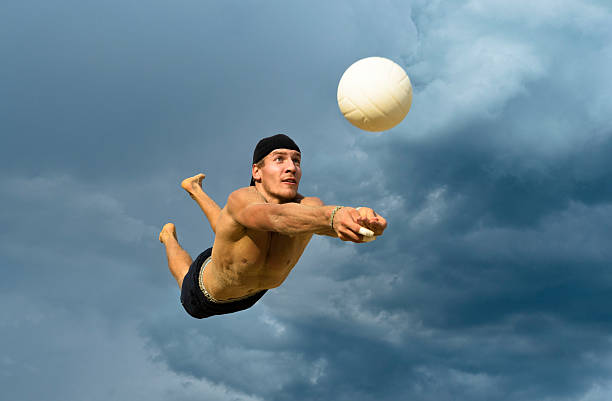 jogador de voleibol masculino em atraente acção contra o céu nublado - volleyball volleying human hand men imagens e fotografias de stock