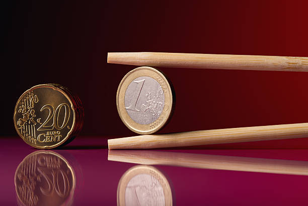 istock One euro coin and chopstick over red background 470979090