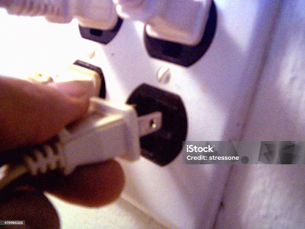 Plug Away1 Holding a electrical plug, with multiple plugs and outlets in the background. Cable Stock Photo