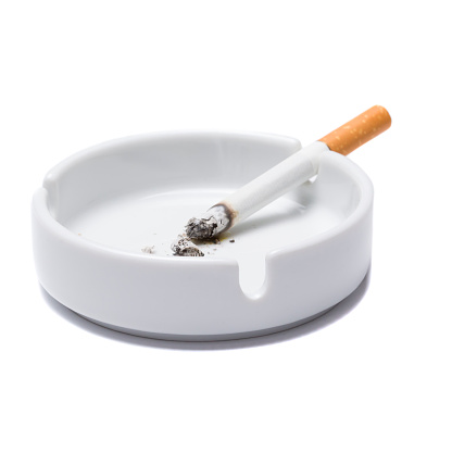 Lit cigarette isolated on white background close up top view