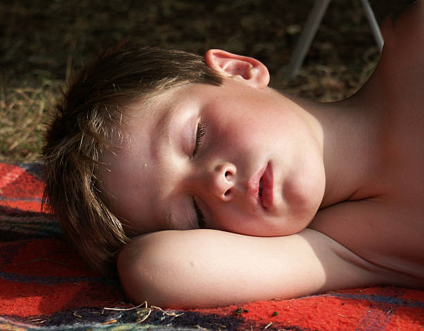 The sleeping boy on the wooden bench