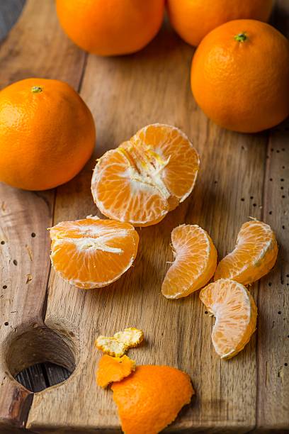 istock fresh tangerines on wooden cutting board 470989126
