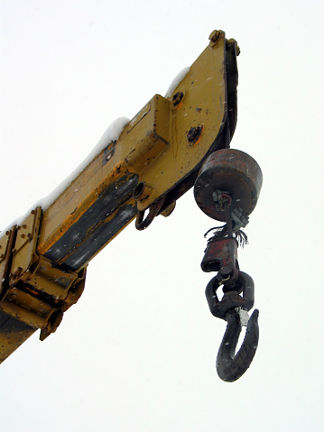 A shot of a crane hook and arm in the snow against an almost white sky.  Taken from farther back so the perspective is not distorted like in 