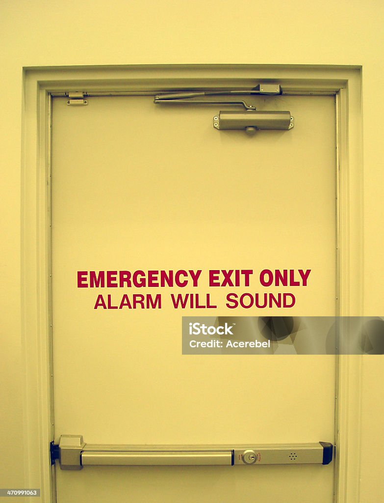 Emergency exit door Partial view of an emergency exit door, reading as well "alarm will sound". Built Structure Stock Photo
