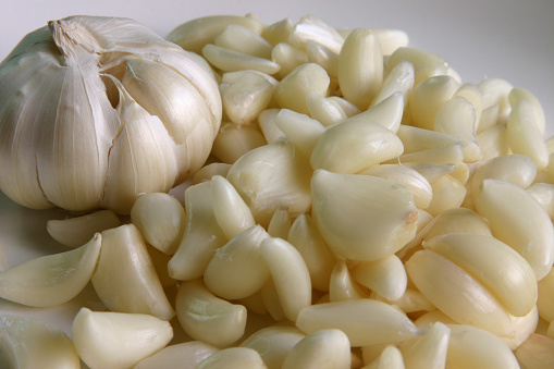 Whole garlic cloves with a complement of peeled garlic cloves.