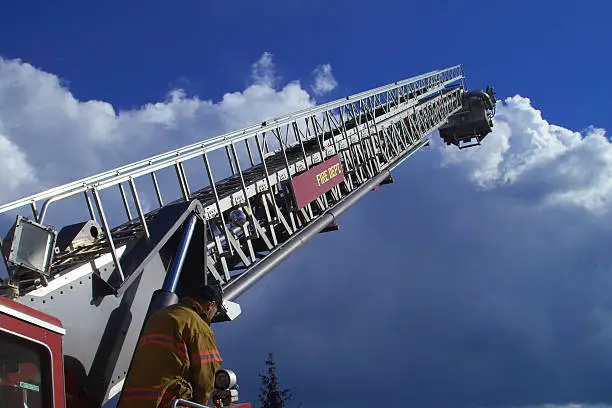 firefighter raising the ladder of a fire truck