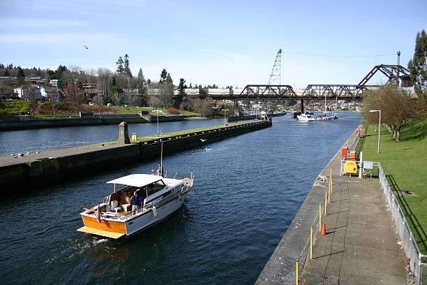 Boat leaving the Ballard Locks Boat leaving the Ballard Locks during high tide. ballard-seattle stock pictures, royalty-free photos & images