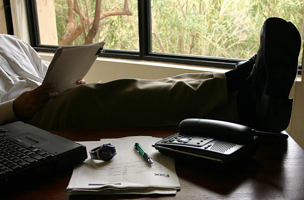 Empresário na mesa com os pés para cima - fotografia de stock