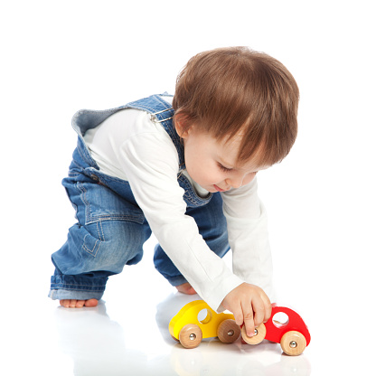 Adorable toddler playing with toy cars, isolated on white