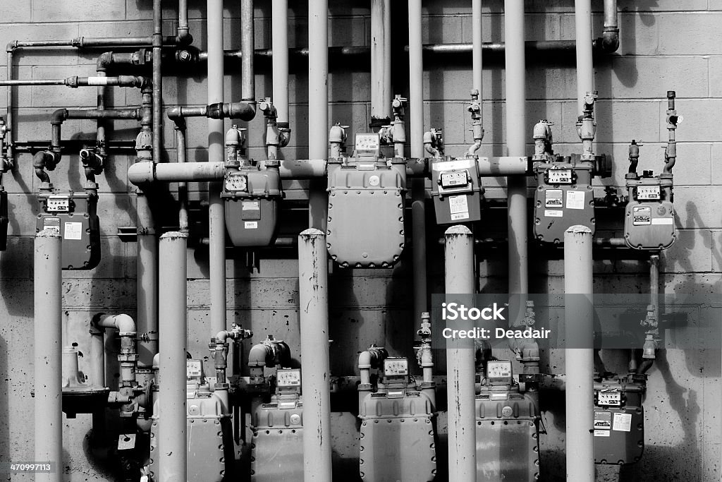 Electric Nightmare in B&W Electric & Gas pipes interwoven across each other..  Abundance Stock Photo