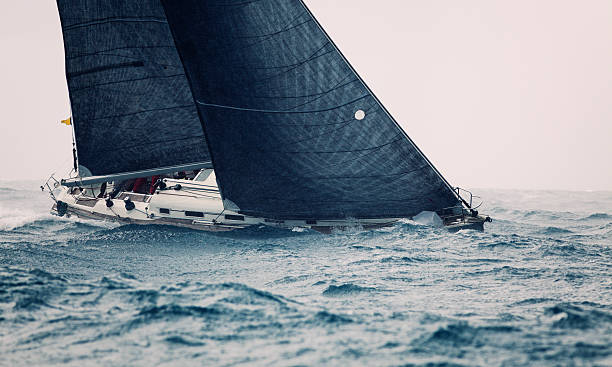 istock Boat with large black sails on the ocean 470997404