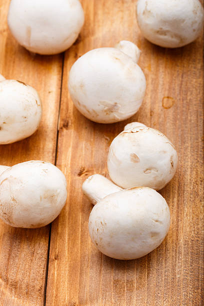 istock champignons closeup on wooden background 470998196