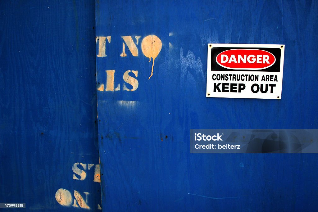 post no bills danger construction bgnd wooden boarding surounding a construction site with warning sign and paint dripping stenciling Backgrounds Stock Photo
