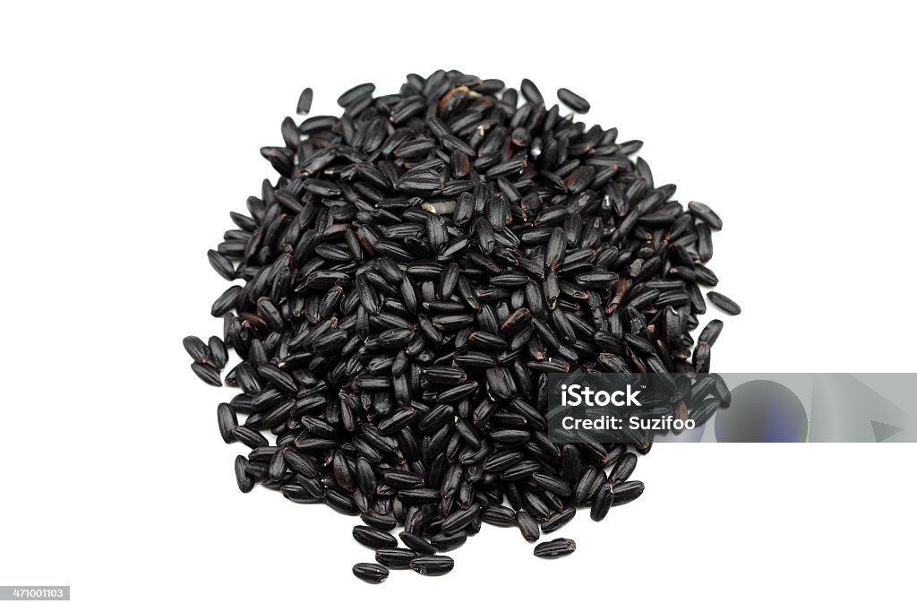 black "forbidden" rice This is a specialty short grain black rice which when cooked turns a deep purple color (it really does, I finally cooked some). It is its natural color - it hasn't been dyed. It's called forbidden rice because it supposedly used to be grown only for the Chinese emperor. It is a whole grain. Isolated on white. Rice - Food Staple Stock Photo