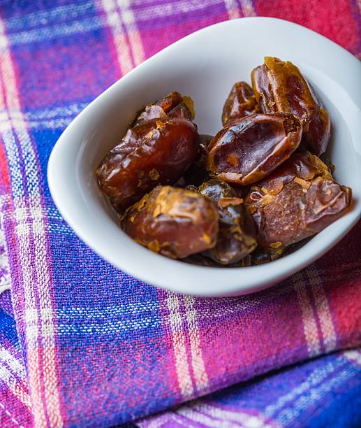 istock Dried dates in bowl on wooden table 471008828