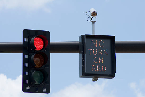 Red Light No Turn Red traffic light with "No Turn On Red" sign and intersection camera. red light stock pictures, royalty-free photos & images
