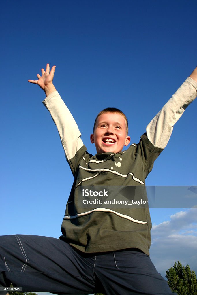 Tada A young smiling boy in a "TADA POSE". Shot against blue sky with trees visible in background.  Plenty of space for copy. Beauty Stock Photo