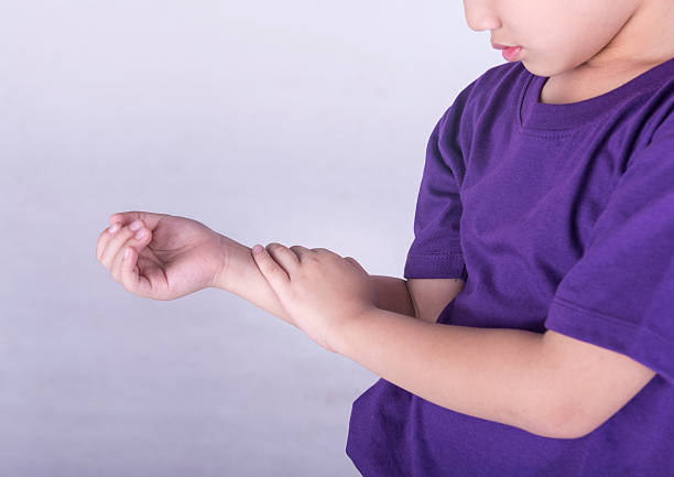 A young boy in a purple shirt checking his pulse stock photo