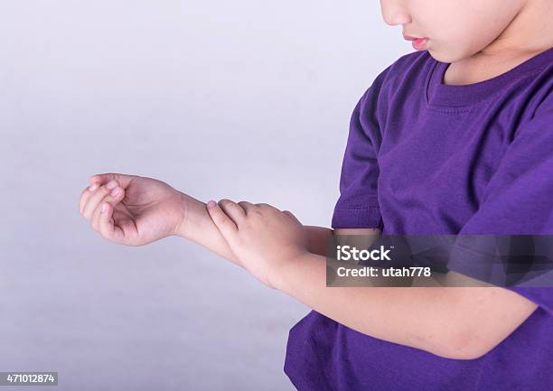 A Young Boy In A Purple Shirt Checking His Pulse Stock Photo - Download Image Now - Child, Arthritis, Pain