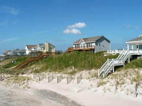 A row of beach houses on sand dunes.