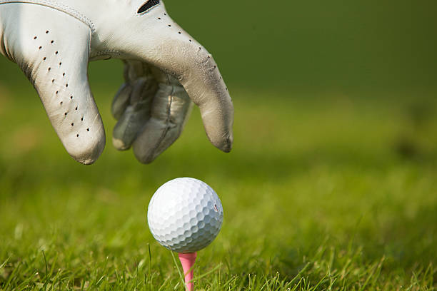 istock Human hand positioning golf ball on tee, close-up 471015034