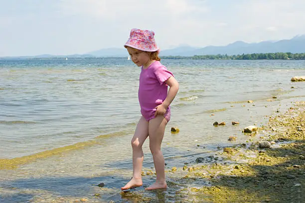 Photo of girl at sea on slithery pebbles