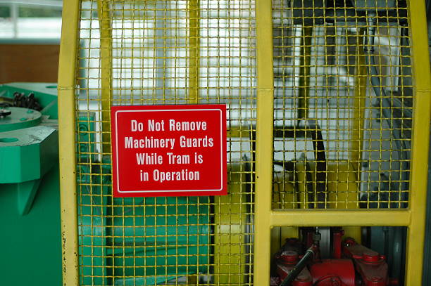Warning Sign A warning sign saying "Do not remove machine guards while tram is in operation". machine stock pictures, royalty-free photos & images