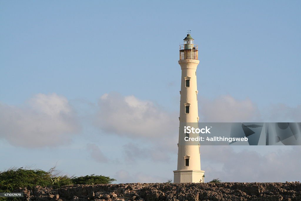 Lighthouse on the Rocks in Aruba Horizontal picture of a lighthouse on the rocks near sunset with blue sky. California lighthouse in Aruba Aruba Stock Photo