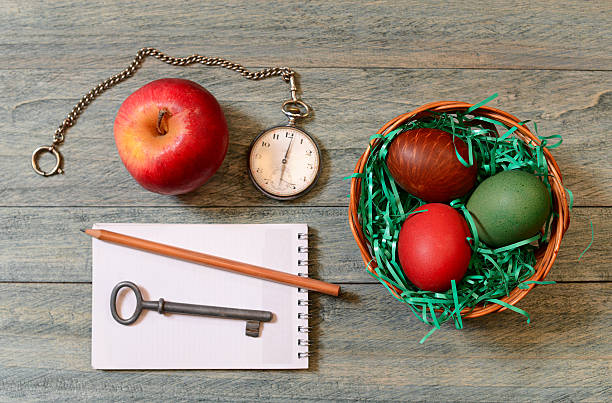 Easter eggs in a basket, apple and pocket watch