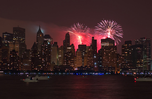 Manhattans Skyline (seen from the islands west) is light up nicely by the fireworks of the 4th of july (independence day) celebrations. The fireworks have been sponsored by the big department store chain \