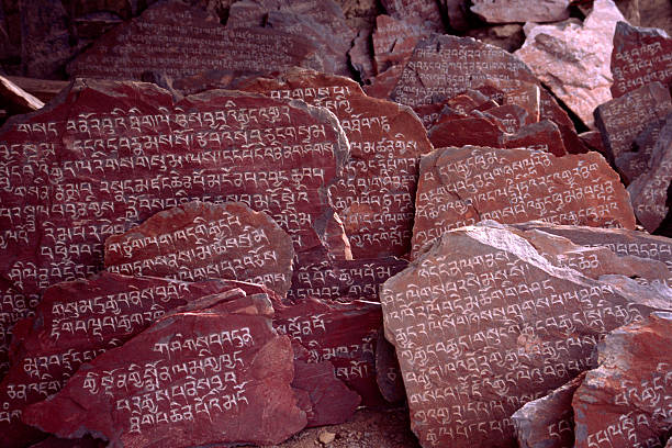 조각된 매니 결석 니어 lhasa, tibet - sanskrit om symbol tibet religious text 뉴스 사진 이미지