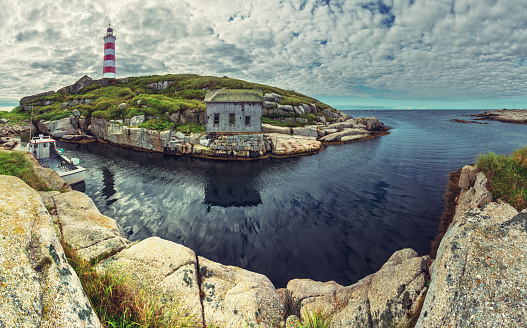 A fishing boat is moored in the narrow harbour at Sambro Island Lighthouse. Built in 1758 it is the oldest operating lighthouse in North America.