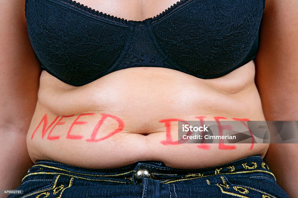 Need diet (overweight female belly) Close-up of an overweight female belly with "Need diet" sign on it. High resolution - 16 Mpx. Addiction Stock Photo