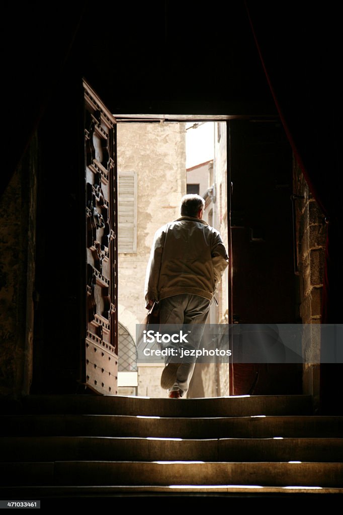 fast exit man leaving old building into bright sunshine Church Stock Photo