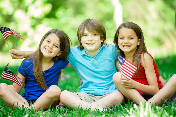 istock Children hold American flags outdoors, summer. Memorial Day, July 4th. 471034358
