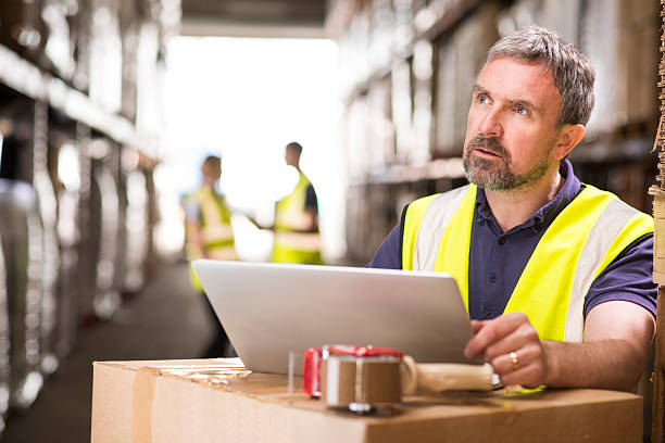 istock warehouse manager checking deliveries on his laptop 471034570