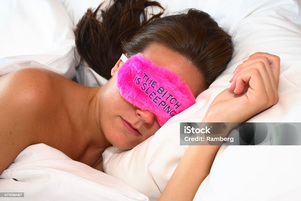 Sleeping beauty and eye cover Sleeping girl wearing an eye shade with the text "The bitch is sleeping" Adult Stock Photo