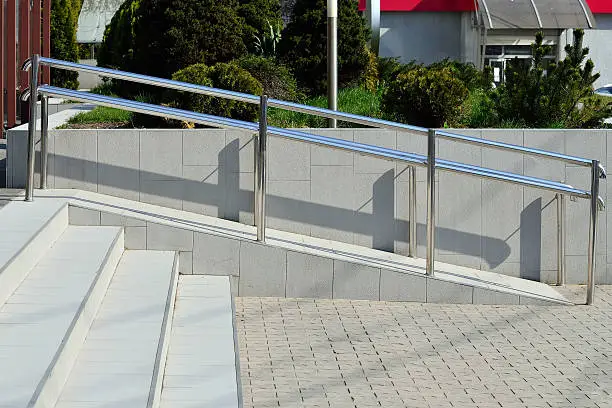 Ramp for wheelchair entry with metal handrails