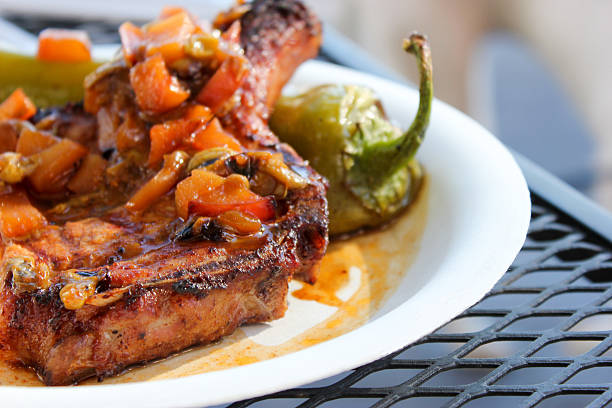 This image shows a pork chop cooked in Mexican style, with roasted peppers.