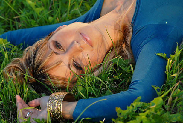 istock Attractive blond girl lying on grass, close up 471046259