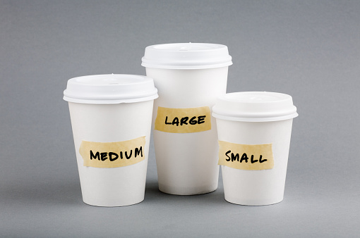 Three disposable coffee cups in a group, with labels 